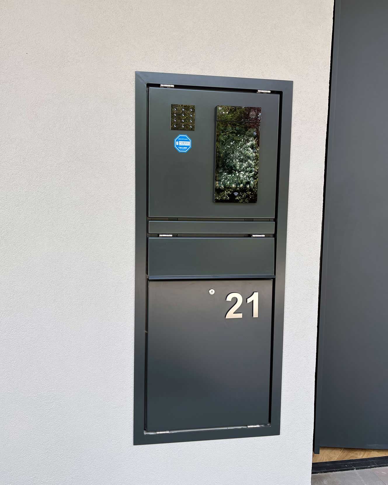 Anthrazitfarbene Unterputz-Türstation mit Video-Sprechanlage, Display, Briefeinwurf und Hausnummer 21, bündig in die Fassade eingelassen.